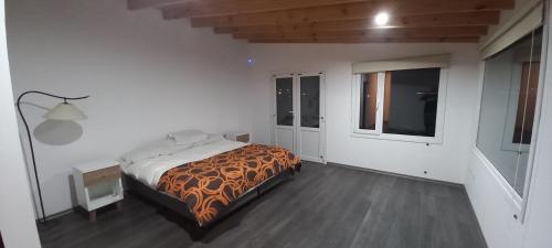a white bedroom with a bed and a window at La Cabañita in El Calafate