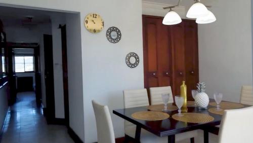 a dining room with a table and a clock on the wall at Apartamento Vista azul rodadero Laureles 801 in Rodadero