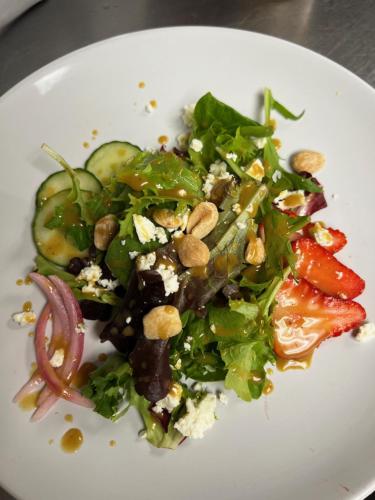 un plato blanco con ensalada con verduras y nueces en Channel Bass Inn and Restaurant en Chincoteague