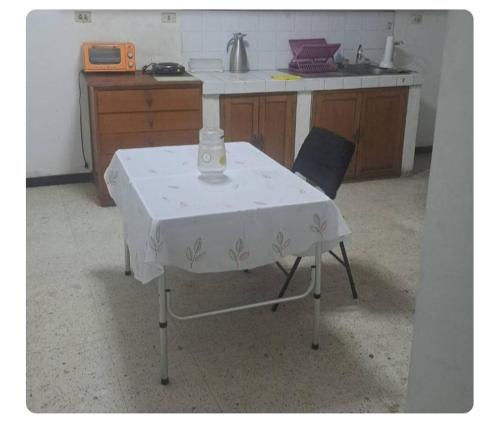 a table with a white table cloth on it in a kitchen at Sientete en casa in Ilo