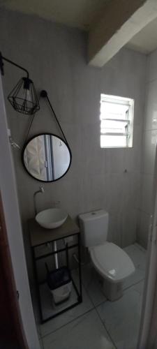 La salle de bains est pourvue de toilettes, d'un lavabo et d'un miroir. dans l'établissement Casa totalmente climatizada, à São Lourenço do Sul