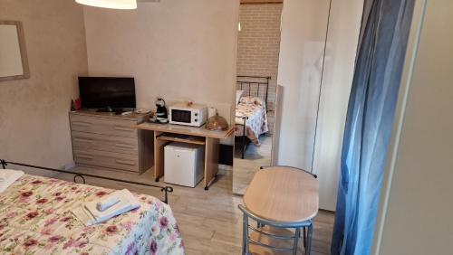 1 dormitorio con 1 cama y escritorio con microondas en La Casa di Mimmo, en Gradara