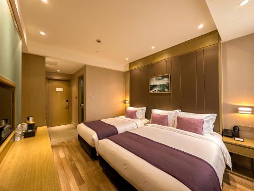 a hotel room with two beds with purple pillows at SHANGHAI-DECO Hotel-Free shuttle bus to Pudong Airport and Disneyland in Shanghai