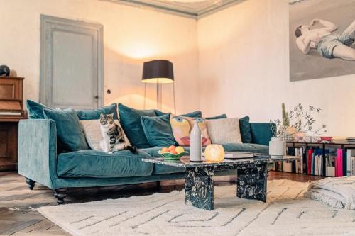 um gato sentado num sofá numa sala de estar em La Nuit & Le Jour em Vertheuil-en-Médoc