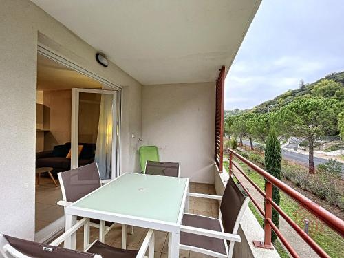 un balcon avec une table et des chaises dessus dans l'établissement Appartement F2 climatisé à Lamalou-les-Bains, terrasse, proche centre et thermes, animaux acceptés - FR-1-451-167, à Lamalou-les-Bains