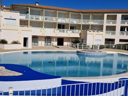 une grande piscine devant un immeuble dans l'établissement Appartement avec Piscine, Tennis & Balcon, Centre-ville Chatelaillon-Plage, 6 Pers, 2 Ch - FR-1-706-17, à Châtelaillon-Plage