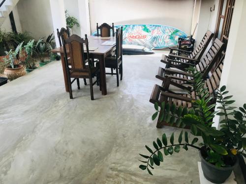 a dining room with a table and chairs and plants at Royal Resort in Weligama
