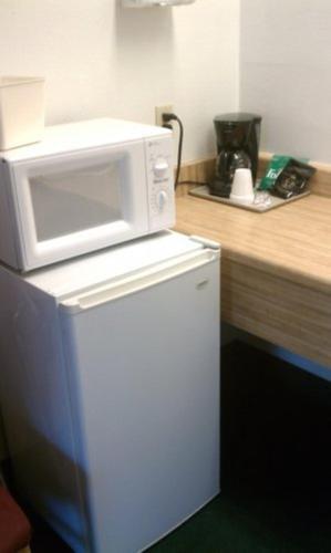 a microwave on top of a refrigerator in a kitchen at Stagecoach Motel in Grass Valley