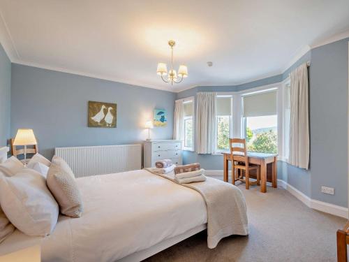 a bedroom with a large white bed and a desk at 4 Bed in Lamlash CA369 in Lamlash