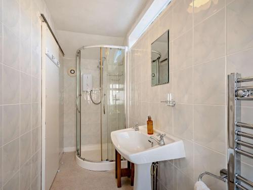 a white bathroom with a sink and a shower at 4 Bed in Lamlash CA369 in Lamlash