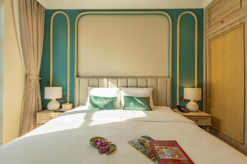 a bedroom with a large bed with blue walls at Stella Marina Boutique Hotel in Phu Quoc