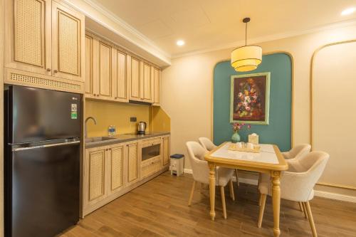 a kitchen with a table with chairs and a refrigerator at Stella Marina Boutique Hotel in Phu Quoc