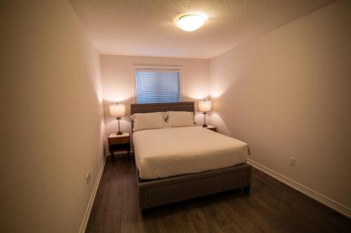 a bedroom with a bed with two lamps on it at Designer 3-Bedroom executive townhouse in Grimsby