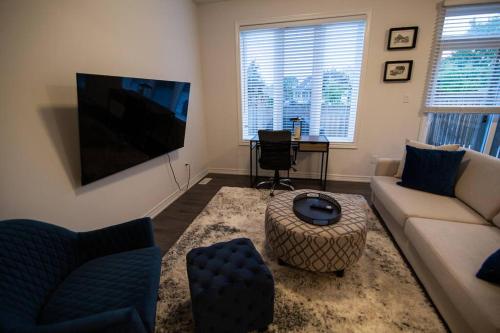 a living room with a couch and a flat screen tv at Designer 3-Bedroom executive townhouse in Grimsby
