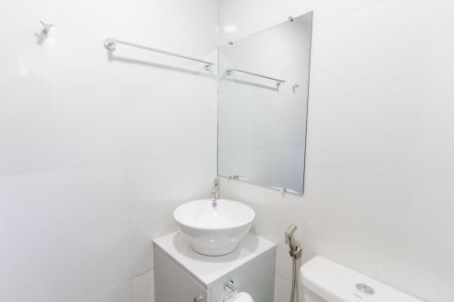 a white bathroom with a sink and a mirror at Le Dream Hotel near Vigan in Anomang Mayor