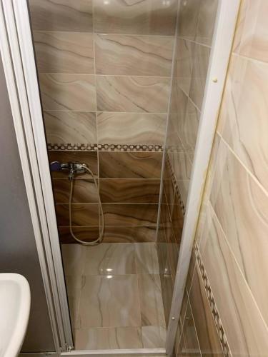 um chuveiro com uma porta de vidro ao lado de um WC em Halkalı merkez küçük lüks oda em Istambul