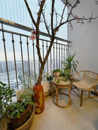 Zimmer mit einem Balkon mit Pflanzen und einem Tisch in der Unterkunft LuxurySunlit/2bed/P10Times in Hanoi