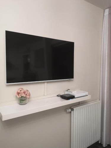 a flat screen tv on a white wall at Grand T2 avec jardin et parking proche Paris et Orly in Orly