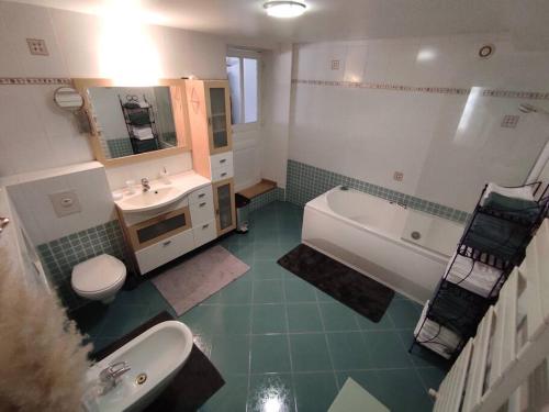 uma casa de banho com um lavatório, uma banheira e um WC. em Chaleureuse maison de ville avec parking gratuit em Chinon