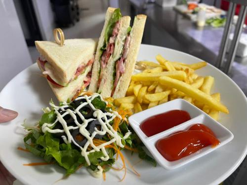 einen Teller mit einem Sandwich, Pommes Frites und Ketchup in der Unterkunft Lotus Aroma Sapa Hotel in Sa Pa