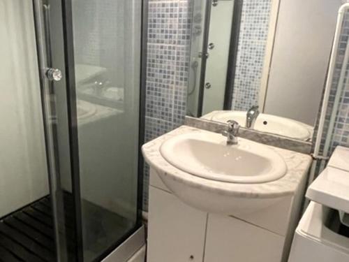 een witte badkamer met een wastafel en een douche bij Appartement Cap d'Agde, 3 pièces, 6 personnes - FR-1-769-4 in Cap d'Agde
