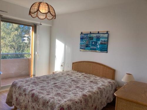 ein Schlafzimmer mit einem Bett und einem großen Fenster in der Unterkunft Appartement Le Lavandou, 2 pièces, 4 personnes - FR-1-308-185 in Le Lavandou