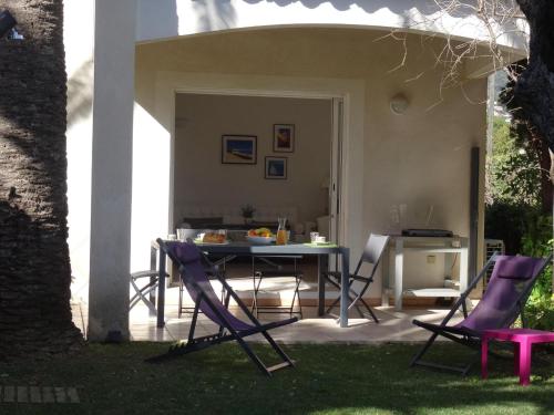 un patio avec une table et des chaises dans une cour dans l'établissement Villa 4*** à 20m de la plage, jardin, parking, clim, WIFI - FR-1-728-15, à Cavalaire-sur-Mer