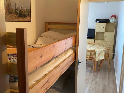une chambre avec un lit superposé et une table dans l'établissement Appartement rénové de 2 pièces au calme, proche des commerces et navette gratuite, parking inclus - FR-1-593-105, aux Angles
