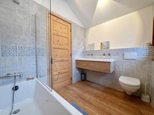 une salle de bain avec une baignoire, des toilettes et un lavabo dans l'établissement Appartement calme près du lac avec jardin, balcon, parking et wifi - FR-1-624-150, à Samoëns