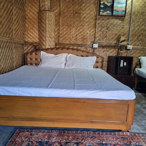 a bedroom with a bed with a blue bedspread at Alohi The terrace Homestay in Tezpur