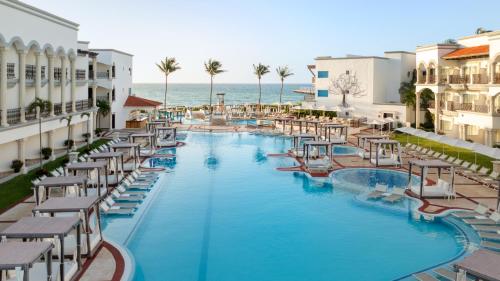 una imagen de una piscina en un complejo en Hilton Playa del Carmen, an All-Inclusive Adult Only Resort, en Playa del Carmen