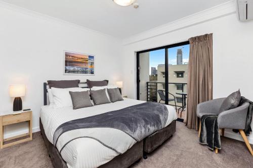 a bedroom with a bed and a chair and a window at City View 1br Gem On Mounts Bay Road in Perth