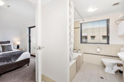a bedroom with a bed and a tub and a sink at City View 1br Gem On Mounts Bay Road in Perth