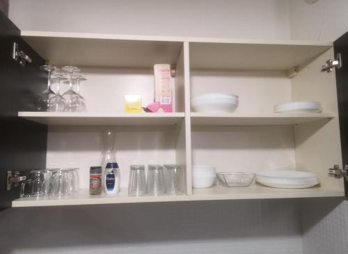 a kitchen shelf with plates and dishes on it at Grand T2 avec jardin et parking proche Paris et Orly in Orly