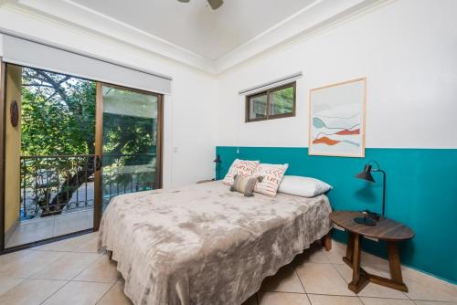 a bedroom with a bed and a large window at Beautiful newly refurbished 2 bedroom 2 Bathroom 2nd floor condo in Tamarindo