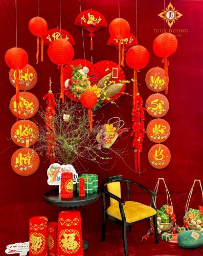 a red wall with red lanterns and a table with a chair at Thuy Duong Boutique Hotel Hue in Hue