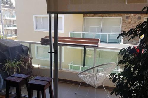 einen Balkon mit einem Tisch und Stühlen sowie einem Fenster in der Unterkunft Quebrada de la Candelaria III in Algarrobo