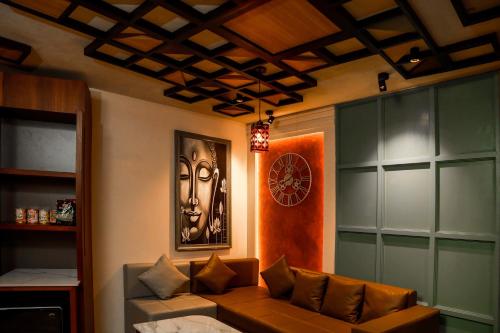 a living room with a couch and a clock on the wall at Kuruva Island Resort And Spa - By KABINI BREEZE in Mananthavady