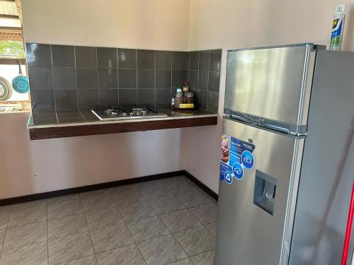 a kitchen with a stainless steel refrigerator and a counter at Rangiroa Bliss in Tiputa