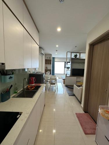 a kitchen with white cabinets and a living room at Nàng Homestay in Gia Lâm Pho