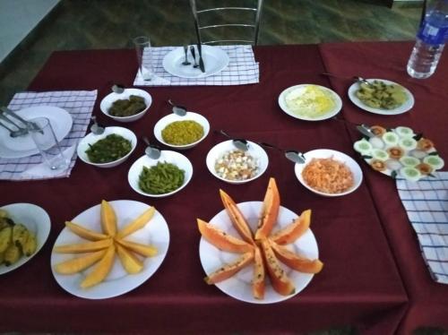 a table with white plates of food on it at Jungle Lodge in Udawalawe