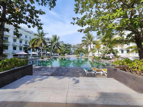 a swimming pool with two chairs and a building at Stella Marina Boutique Hotel in Phu Quoc