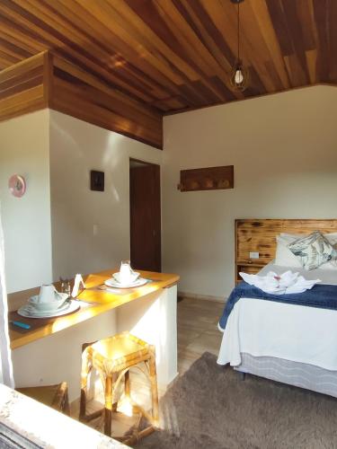 a bedroom with a bed and a table with dishes on it at Chalé Sonho Diniz 1 in Monte Verde
