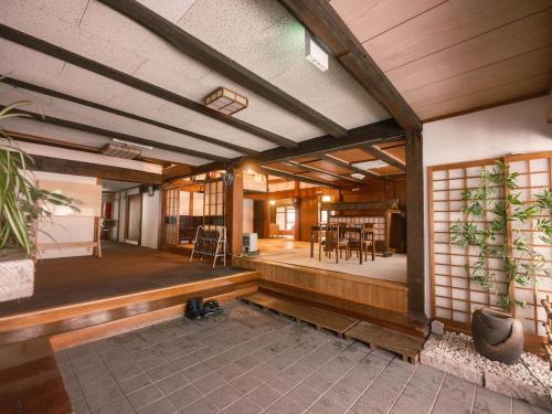 a large room with a table and chairs in it at 古民家ホテル 結 YUWAI in Hakuba
