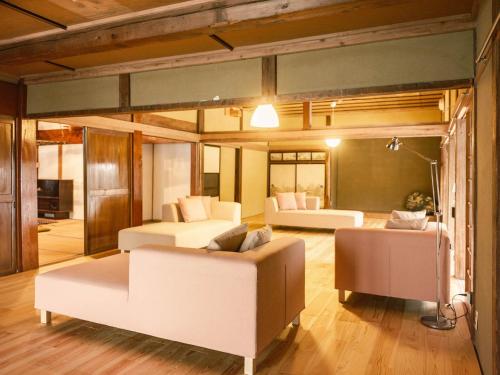 uma sala de estar com duas camas e um sofá em 古民家ホテル 結 YUWAI em Hakuba