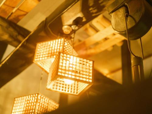 a group of lights hanging from a ceiling at 古民家ホテル 結 YUWAI in Hakuba