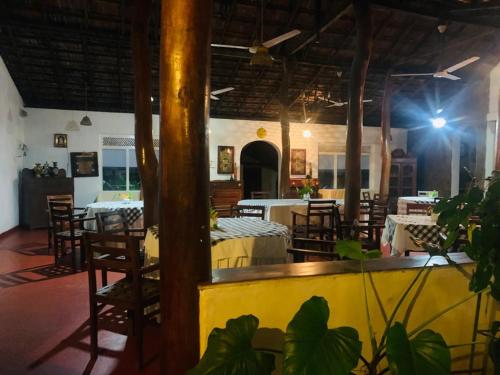 un restaurante con mesas y sillas en una habitación en Habarana INN, en Habarana