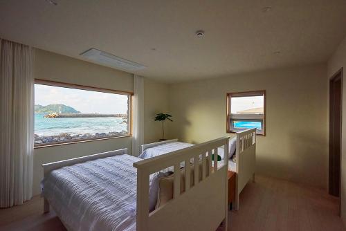 a bedroom with a bed and a large window at Hey Day Jeju in Jeju