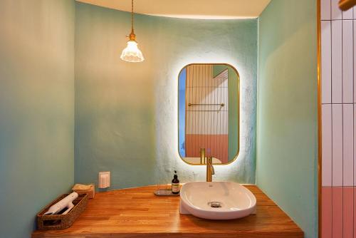 W łazience znajduje się umywalka i lustro. w obiekcie Hay Day Jeju w mieście Czedżu