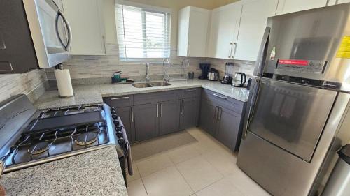 a kitchen with a stainless steel refrigerator and a sink at Seashore Vacation Home, Oceanpointe, Lucea, Jamaica in Point